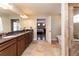 Bathroom with dual vanity, tiled floor, and a doorway to the main bedroom at 1665 Avery Way, Castle Rock, CO 80109