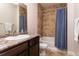 Full bathroom with tile floors and walls, a tub with shower, and dark wood vanity at 1665 Avery Way, Castle Rock, CO 80109