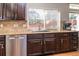 Well-lit kitchen features granite counters, stainless steel dishwasher, and dark wood cabinets at 1665 Avery Way, Castle Rock, CO 80109