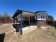 Backyard area featuring a covered patio, brick accents, and a spacious yard at 7021 Saulsbury St, Arvada, CO 80003