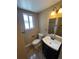 Cozy bathroom with tiled floors, single sink vanity, toilet, and a window for natural light at 7021 Saulsbury St, Arvada, CO 80003