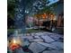 Inviting backyard featuring a stone patio with a cozy fire pit and string lights over a wooden deck at 23662 E Alabama Dr, Aurora, CO 80018