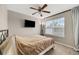 Cozy bedroom features a TV, a ceiling fan, and a large window for natural light at 23662 E Alabama Dr, Aurora, CO 80018