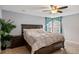Inviting bedroom features a dark wood bed, side table, ceiling fan, and cozy carpet at 23662 E Alabama Dr, Aurora, CO 80018