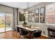 Stylish dining area with modern light fixtures, a large table, and views of the backyard at 23662 E Alabama Dr, Aurora, CO 80018