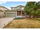 Charming two-story home with a well-manicured lawn, stone accents, and an attached two car garage at 23662 E Alabama Dr, Aurora, CO 80018