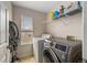 Bright laundry room with modern washer and dryer and ample storage space at 23662 E Alabama Dr, Aurora, CO 80018