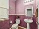 Cozy powder room showcases pedestal sink, decorative mirror, and mauve textured walls at 23662 E Alabama Dr, Aurora, CO 80018