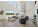 Sunlit living room with soaring ceilings, stone fireplace, large windows offering scenic views, and stylish furnishings at 2515 Clayton Cir, Superior, CO 80027