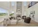 Bright and airy living room with a soaring stone fireplace, ample seating, and large windows overlooking the green outdoors at 2515 Clayton Cir, Superior, CO 80027