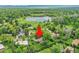 Aerial view of a property in a green neighborhood, highlighting the home's location amidst mature trees and a nearby lake at 595 W Lake Ave, Littleton, CO 80120