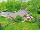 Aerial view of a beautiful brick home with a large patio area, mature trees, and a well-maintained lawn at 595 W Lake Ave, Littleton, CO 80120
