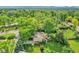 Aerial view of a well-maintained property with lush trees and an outdoor seating area, surrounded by green landscape at 595 W Lake Ave, Littleton, CO 80120