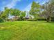 Spacious backyard featuring a large lawn, mature trees, and a charming home with a covered patio area at 595 W Lake Ave, Littleton, CO 80120