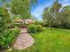 Lush backyard with a brick patio, mature trees, and manicured landscaping, perfect for outdoor entertaining at 595 W Lake Ave, Littleton, CO 80120