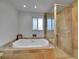 Luxurious bathroom featuring a soaking tub and separate shower with neutral tile and modern fixtures at 595 W Lake Ave, Littleton, CO 80120