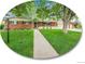 Charming brick home with a well-manicured lawn and mature trees, creating a welcoming curb appeal at 595 W Lake Ave, Littleton, CO 80120