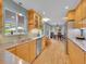 Galley kitchen featuring stainless steel appliances, light wood cabinets, and a breakfast bar at 595 W Lake Ave, Littleton, CO 80120