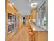 Modern kitchen with stainless steel appliances, wood cabinetry, and breakfast bar seating at 595 W Lake Ave, Littleton, CO 80120