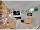 Cozy living room featuring exposed brick, comfortable armchairs, and a modern entertainment center at 595 W Lake Ave, Littleton, CO 80120