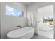 Bright bathroom with a standalone tub and window with a view of the bedroom at 2538 S Acoma St, Denver, CO 80223