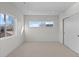 Bright bedroom features neutral carpet, white walls, and abundant natural light from two large windows at 2538 S Acoma St, Denver, CO 80223