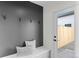 Modern entryway with a gray accent wall, coat hooks, and a bench with decorative pillows at 2538 S Acoma St, Denver, CO 80223