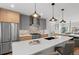 Bright kitchen showcasing two-tone cabinets, stainless steel appliances, pendant lighting, and a spacious island at 2538 S Acoma St, Denver, CO 80223