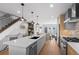 Open-concept kitchen with an island, stainless steel appliances, pendant lights, and a view of the staircase at 2538 S Acoma St, Denver, CO 80223