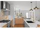 Sleek kitchen equipped with modern appliances, island seating, and seamless connectivity to dining and living areas at 2538 S Acoma St, Denver, CO 80223