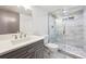 Updated bathroom featuring a glass shower, gray vanity, and modern finishes at 1112-1112 1/2 Krameria St, Denver, CO 80220