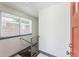 Light and airy hallway with modern metal railing and staircase with natural light coming through the window at 1112-1112 1/2 Krameria St, Denver, CO 80220
