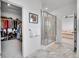 Bright bathroom featuring a glass-enclosed shower, marble floors, and walk-in closet access at 15794 W Girard Ave, Morrison, CO 80465