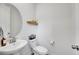Clean, modern powder room with a pedestal sink, round mirror, and minimalist decor at 15794 W Girard Ave, Morrison, CO 80465