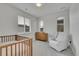 Neutral Bedroom with a crib, wooden dresser, and comfortable armchair at 15794 W Girard Ave, Morrison, CO 80465