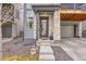 Close-up view of townhome front entrance showcasing rock accents and two-car garage at 15794 W Girard Ave, Morrison, CO 80465