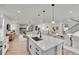 Open-concept kitchen flows into living space, featuring a large island with bar seating and pendant lighting at 15794 W Girard Ave, Morrison, CO 80465