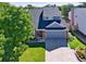 Aerial view of a two-story home with a well-manicured lawn, flowerbeds, and mature trees at 7054 S Flower Ct, Littleton, CO 80128