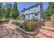 Multi-tiered backyard with stone and brick accents, lush lawn, and patio area at 7054 S Flower Ct, Littleton, CO 80128
