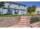 Backyard featuring a stone patio, retaining wall, and lush green lawn, perfect for outdoor entertaining at 7054 S Flower Ct, Littleton, CO 80128