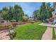 Lush backyard with green lawn, patio seating, and well-maintained wooden fence at 7054 S Flower Ct, Littleton, CO 80128