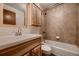 Cozy bathroom featuring wood cabinets, a ceramic vanity, and tile surround at 7054 S Flower Ct, Littleton, CO 80128