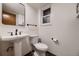 Bathroom features a pedestal sink, toilet, black hardware, and a neutral color scheme at 7054 S Flower Ct, Littleton, CO 80128