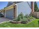 Side view of a two-story home with blue siding, brick accents, and landscaped garden at 7054 S Flower Ct, Littleton, CO 80128