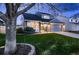 Charming home with gray siding, brick details, two-car garage and lush green lawn and mature trees at 7054 S Flower Ct, Littleton, CO 80128
