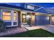 Home exterior showcases brick and gray siding, a two-car garage, and a cozy front entryway at 7054 S Flower Ct, Littleton, CO 80128