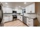 Bright kitchen features white cabinets, stainless steel appliances, granite countertops, and light hardwood floors at 7054 S Flower Ct, Littleton, CO 80128