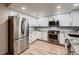 Updated kitchen showcases white cabinetry, stainless appliances, granite countertops, and a modern design at 7054 S Flower Ct, Littleton, CO 80128