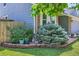 Well-manicured front yard with brick border, lush greenery, and vibrant flowers at 7054 S Flower Ct, Littleton, CO 80128