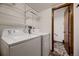 Practical laundry room with shelving, washer, and dryer, plus access to additional space at 7054 S Flower Ct, Littleton, CO 80128